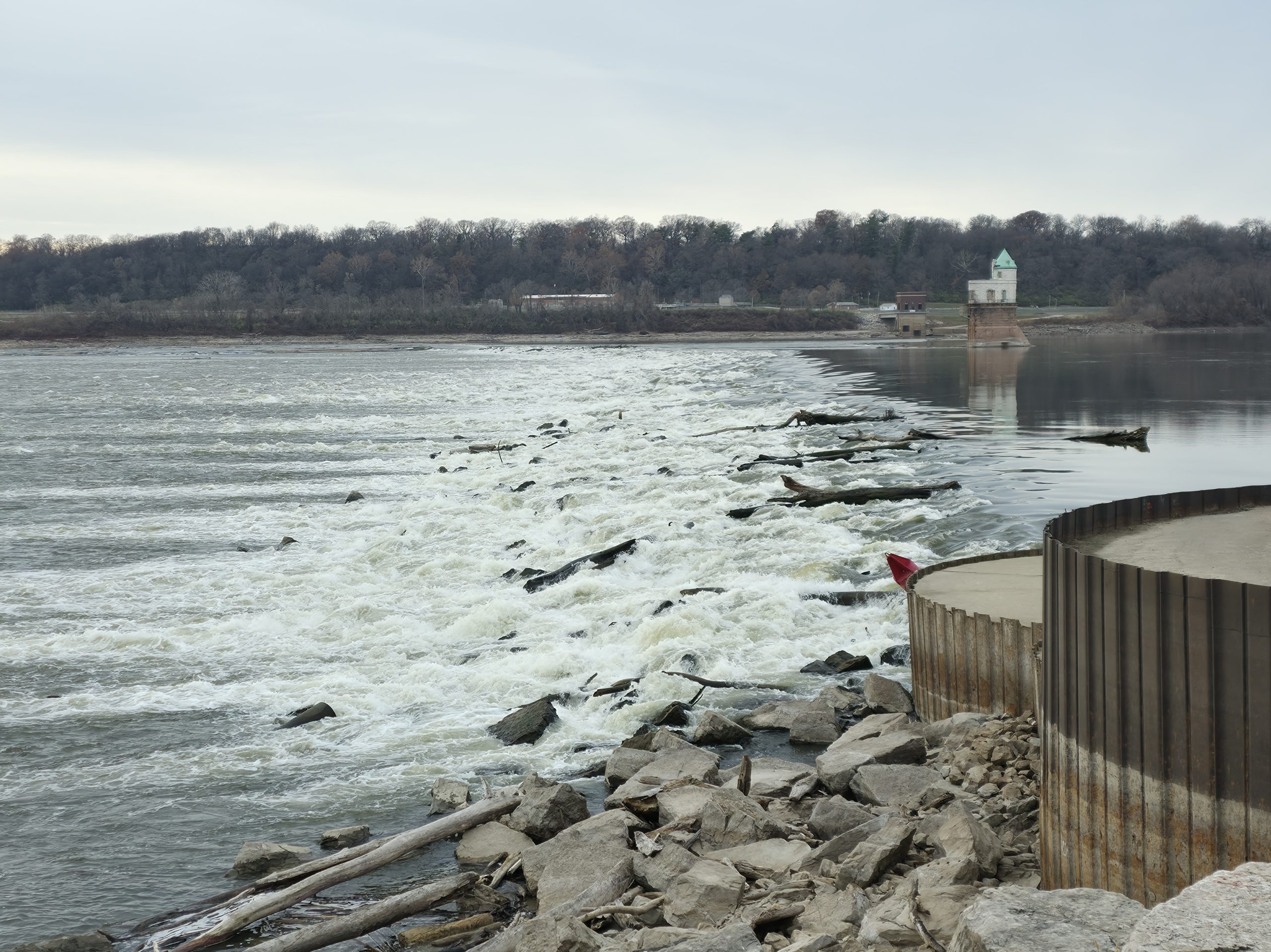 Mississippi River churning against the weathered steel of the Chain of Rocks Bridge under a gray winter sky.