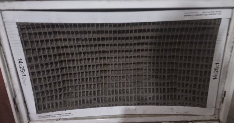 Clogged, dust-caked HVAC air filter labeled 14x25x1 in a white return housing, overdue for replacement